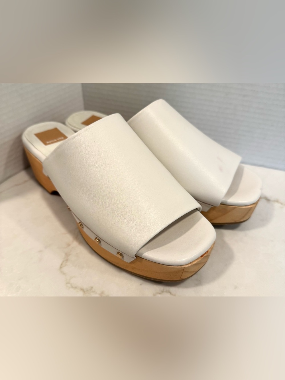 Dolce Vita Dorado white leather platform slide sandals with studded wood heels.